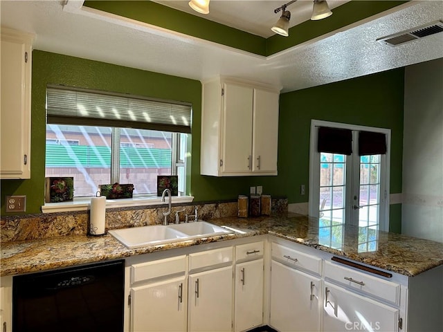 kitchen with dishwasher, stone counters, white cabinets, sink, and kitchen peninsula