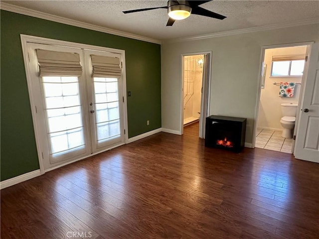 unfurnished bedroom featuring connected bathroom, ceiling fan, dark hardwood / wood-style flooring, crown molding, and a textured ceiling