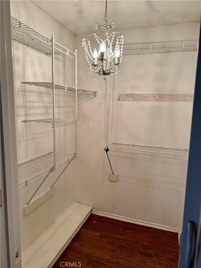 spacious closet featuring a chandelier and wood-type flooring