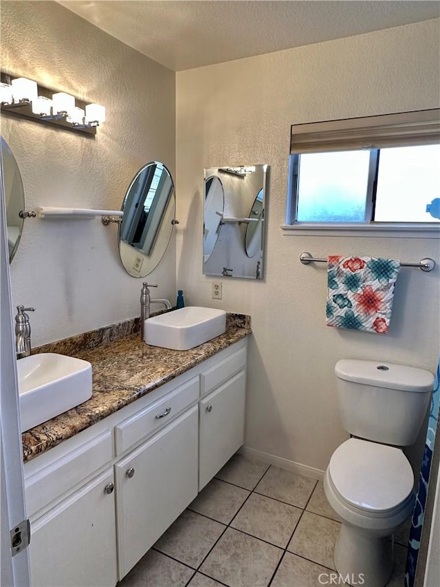 bathroom featuring tile patterned floors, vanity, and toilet