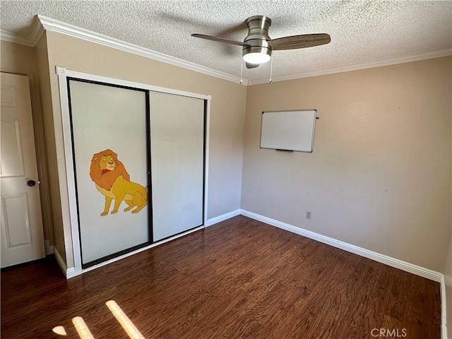 unfurnished bedroom with ceiling fan, a closet, dark hardwood / wood-style floors, and ornamental molding