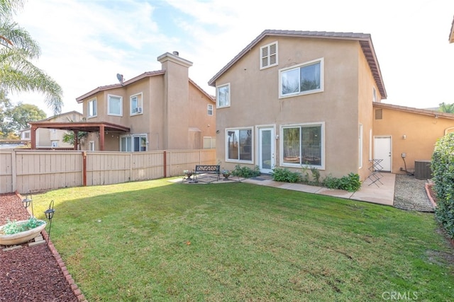 rear view of property featuring a yard and central AC unit