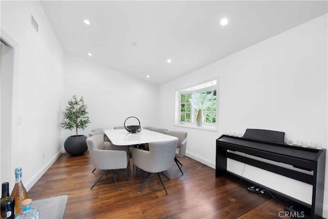 dining room featuring dark wood-type flooring and lofted ceiling