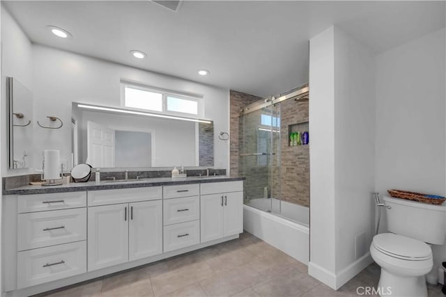 full bathroom with tile patterned flooring, vanity, toilet, and bath / shower combo with glass door