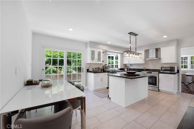 kitchen with white cabinetry, pendant lighting, wall chimney exhaust hood, and stainless steel appliances