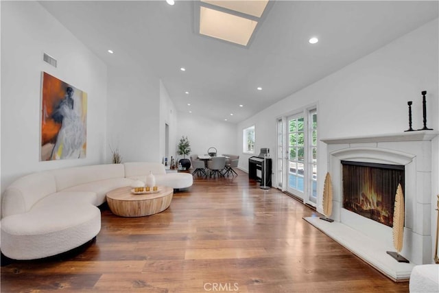 living room with wood-type flooring and vaulted ceiling