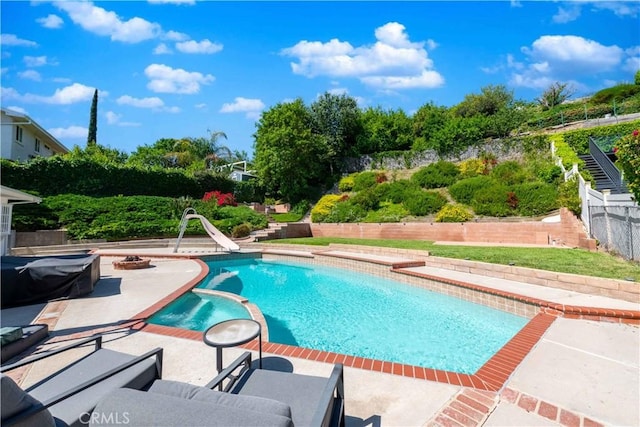 view of pool with a patio, an outdoor fire pit, and a water slide