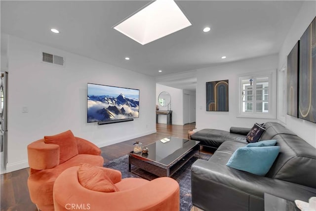 living room with dark hardwood / wood-style flooring and a skylight