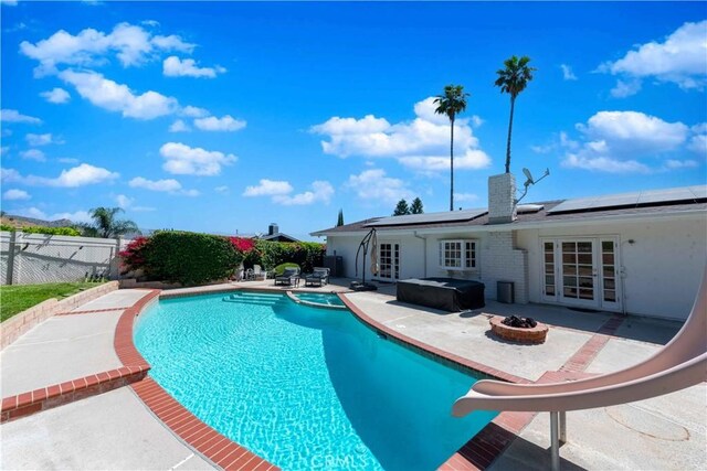 view of pool featuring a grill, an in ground hot tub, french doors, and a patio