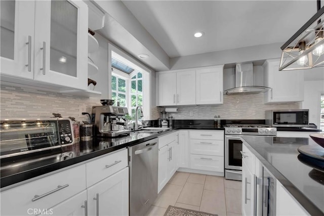 kitchen featuring wall chimney exhaust hood, white cabinetry, and stainless steel appliances