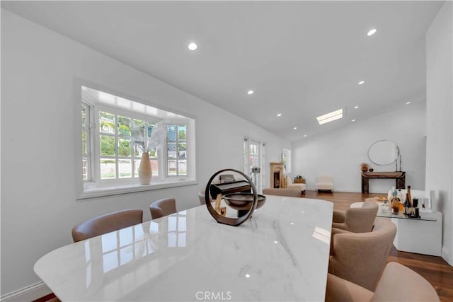 dining room with dark wood-type flooring and lofted ceiling