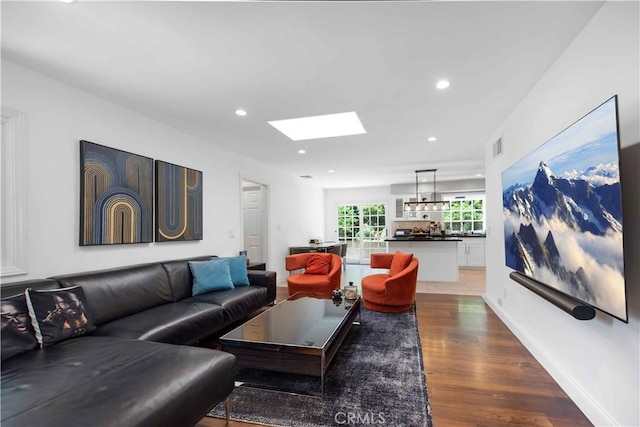 living room featuring a skylight and hardwood / wood-style flooring