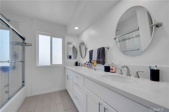 bathroom with vanity and bath / shower combo with glass door