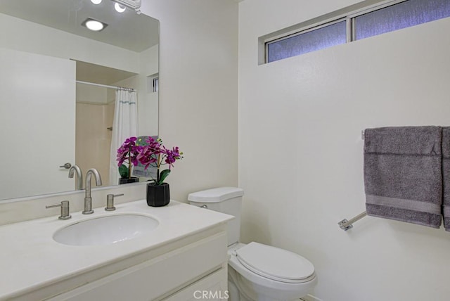 bathroom with a shower with curtain, vanity, and toilet