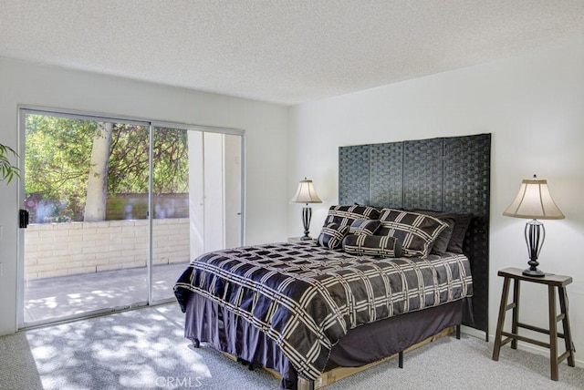 carpeted bedroom featuring a textured ceiling and access to outside