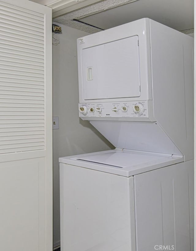 clothes washing area featuring stacked washer / drying machine