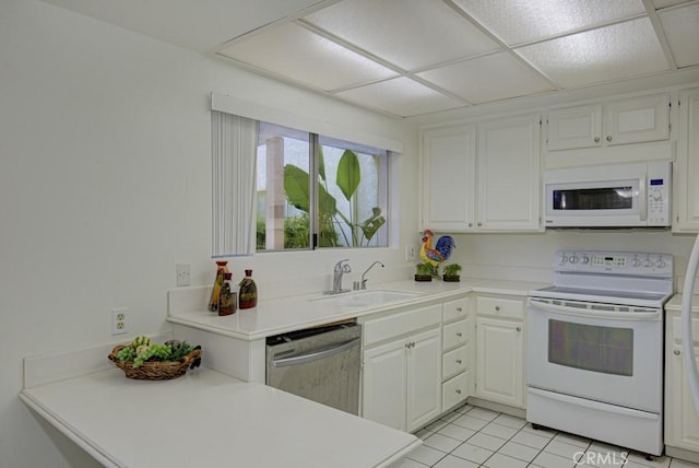 kitchen featuring white cabinets, light tile patterned floors, white appliances, and sink