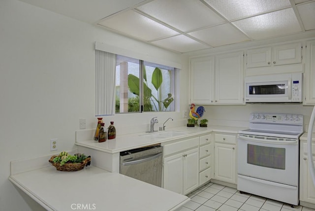 kitchen with a sink, light countertops, white cabinets, and white appliances