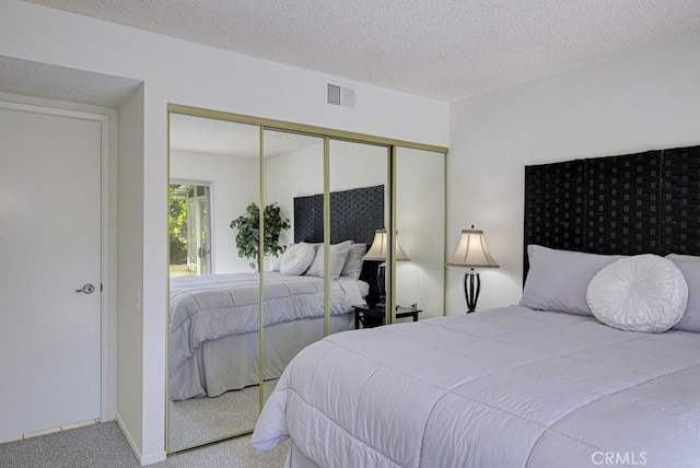 carpeted bedroom featuring a textured ceiling and a closet