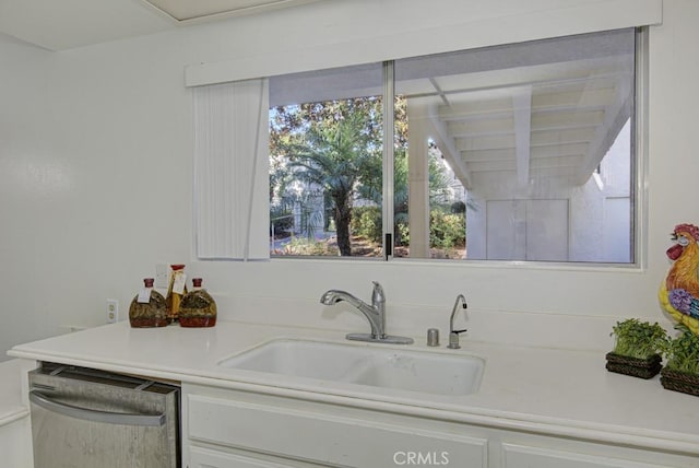 kitchen featuring white cabinets, stainless steel dishwasher, and sink