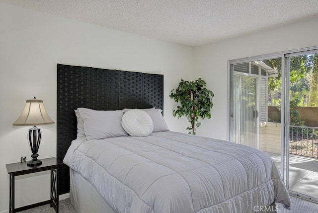 bedroom with access to outside, carpet floors, and a textured ceiling