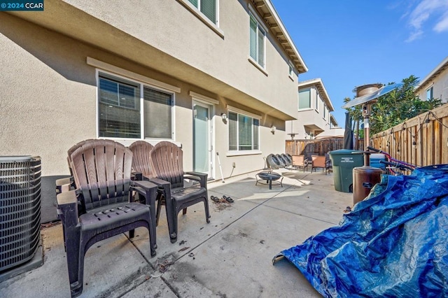 view of patio / terrace with a fire pit and cooling unit