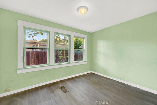 unfurnished room with dark hardwood / wood-style flooring