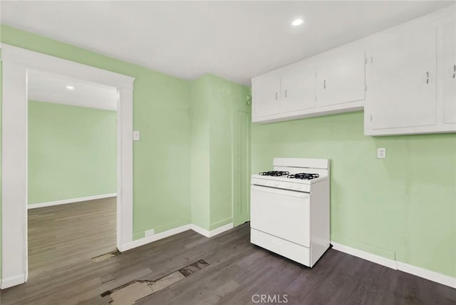 kitchen featuring white range with gas stovetop, dark hardwood / wood-style flooring, and white cabinets