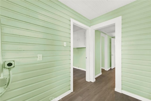 hallway featuring dark hardwood / wood-style floors and wood walls