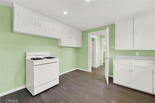 kitchen featuring white range with gas stovetop, white cabinets, and dark wood-type flooring