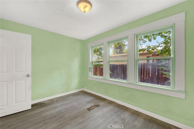 spare room with hardwood / wood-style floors and a wealth of natural light