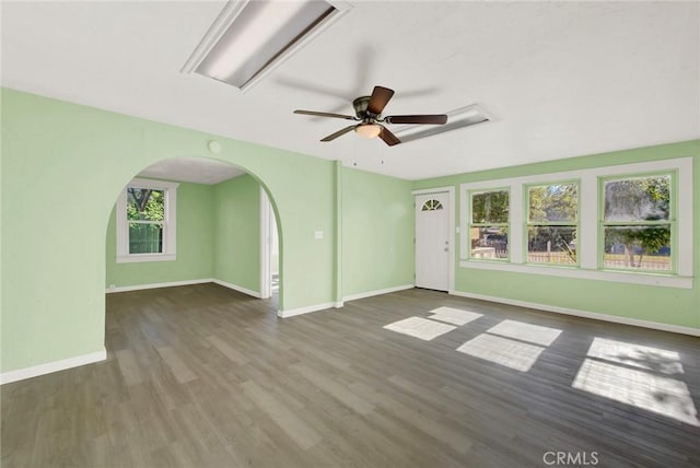 unfurnished living room featuring dark hardwood / wood-style floors and ceiling fan