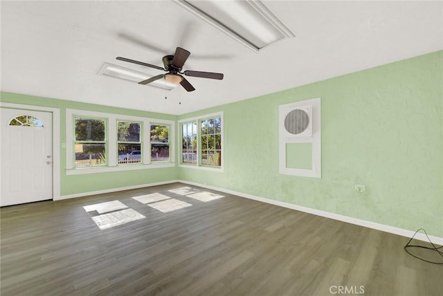 unfurnished living room with ceiling fan, dark hardwood / wood-style flooring, and a healthy amount of sunlight