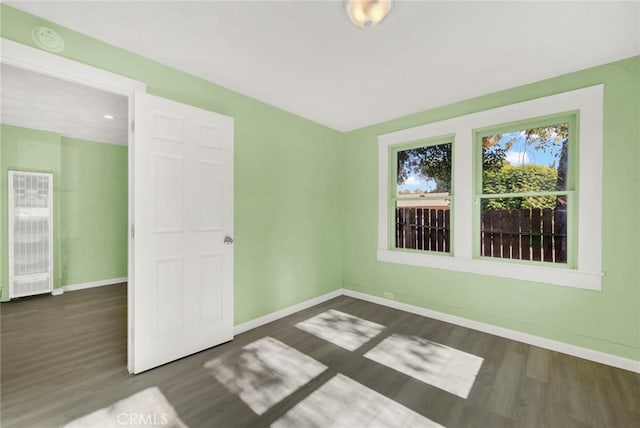 empty room with dark hardwood / wood-style flooring