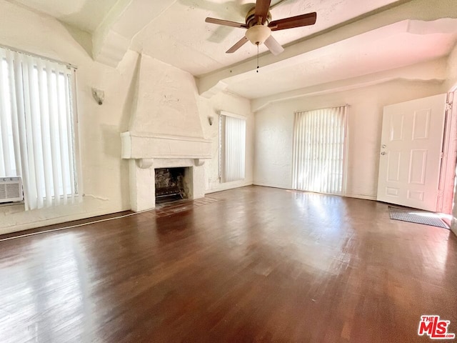 unfurnished living room with beamed ceiling, ceiling fan, dark hardwood / wood-style flooring, and a premium fireplace