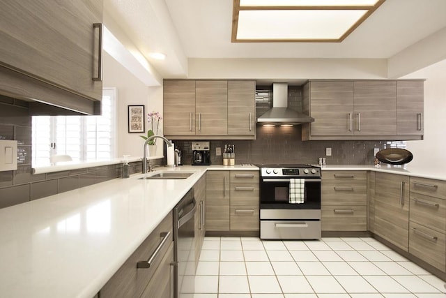 kitchen featuring sink, wall chimney exhaust hood, light tile patterned floors, appliances with stainless steel finishes, and tasteful backsplash