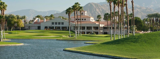 view of property's community featuring a water and mountain view and a lawn