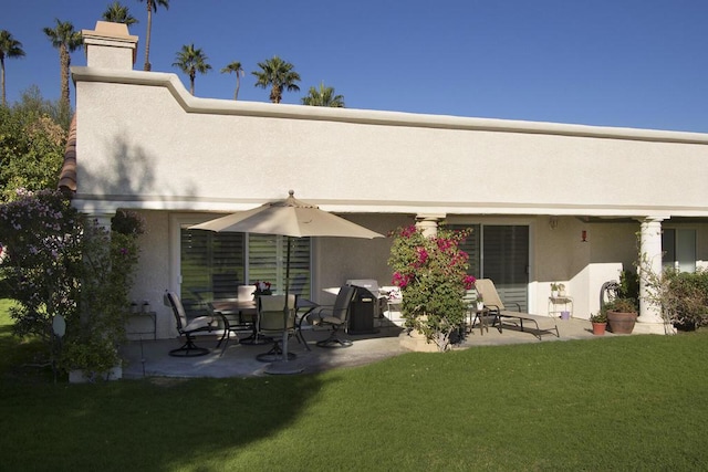 rear view of property with a lawn and a patio