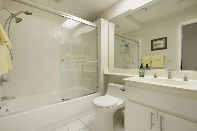 full bathroom with tile patterned floors, vanity, bath / shower combo with glass door, and toilet