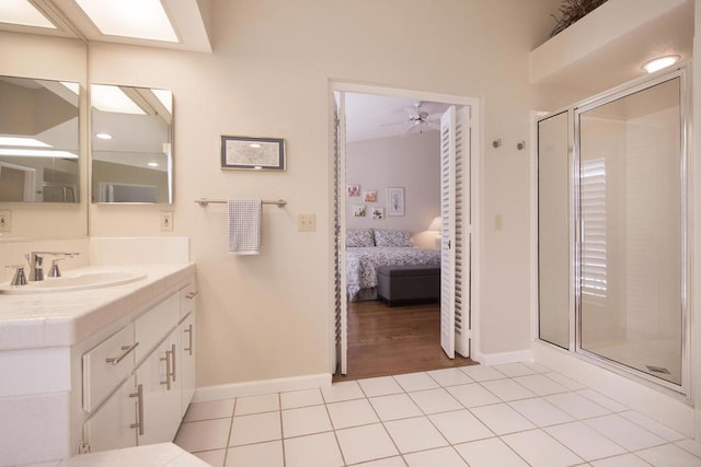 bathroom with tile patterned floors, ceiling fan, vanity, and a shower with shower door