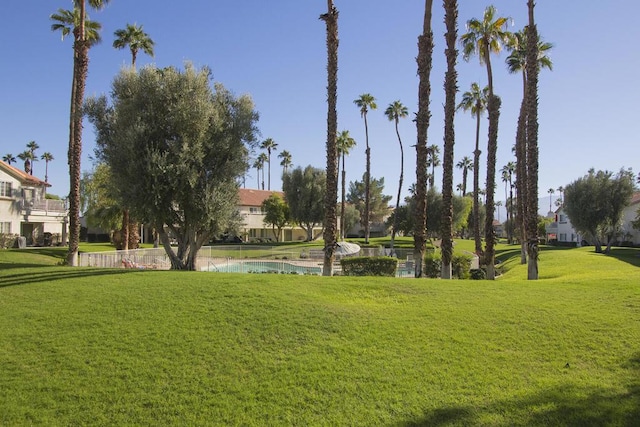 view of property's community with a lawn and a water view