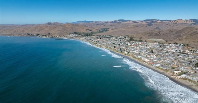 birds eye view of property featuring a water and mountain view and a view of the beach