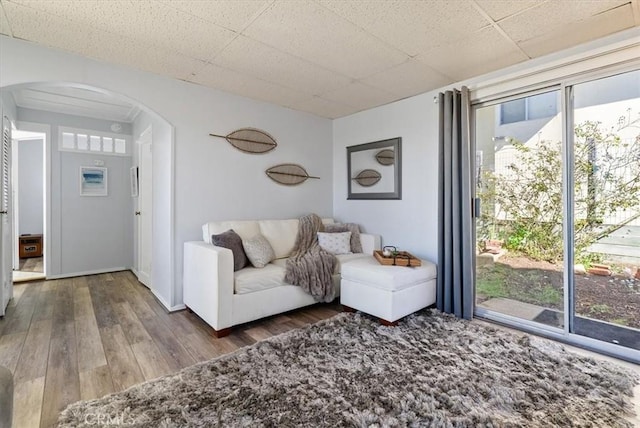 unfurnished living room featuring dark wood-type flooring and a drop ceiling