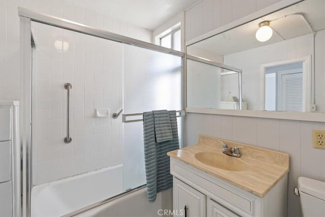 full bathroom featuring toilet, vanity, and shower / bath combination with glass door