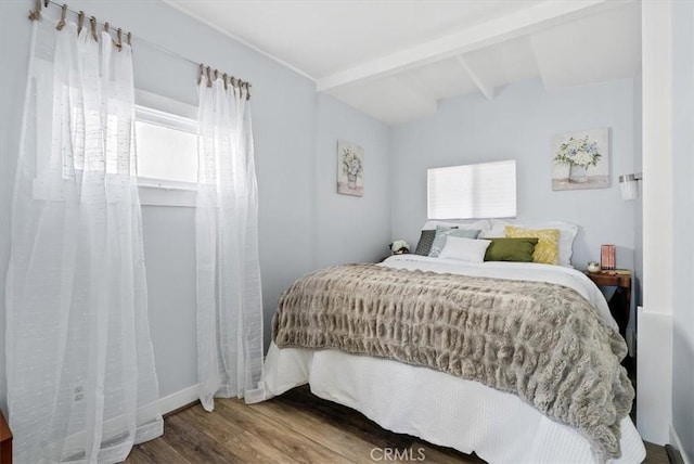 bedroom with beam ceiling and wood-type flooring