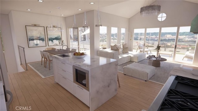 kitchen featuring white cabinets, a kitchen island, decorative light fixtures, plenty of natural light, and built in microwave