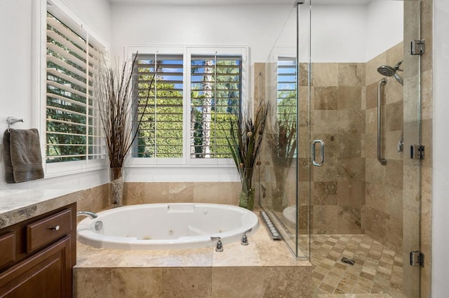 bathroom with plus walk in shower, vanity, and a wealth of natural light