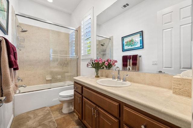 full bathroom featuring vanity, tiled shower / bath combo, and toilet