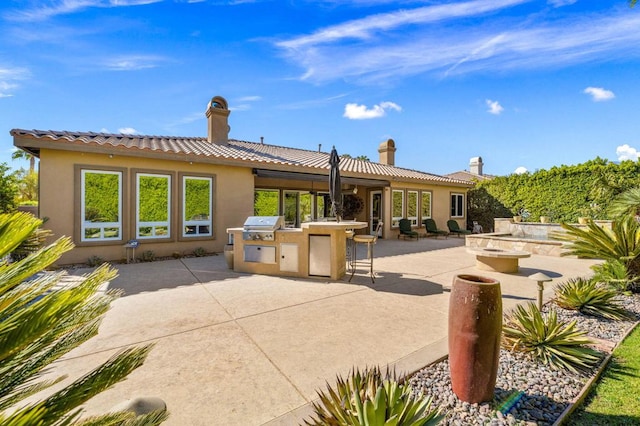 rear view of property featuring area for grilling and a patio