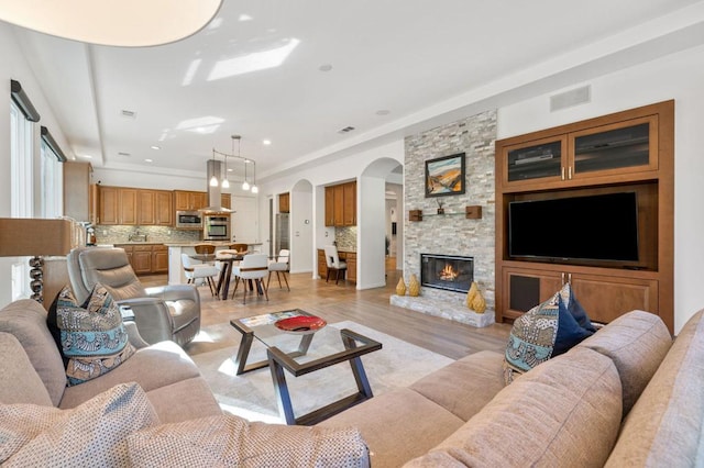 living room featuring a fireplace, light hardwood / wood-style flooring, and ornamental molding